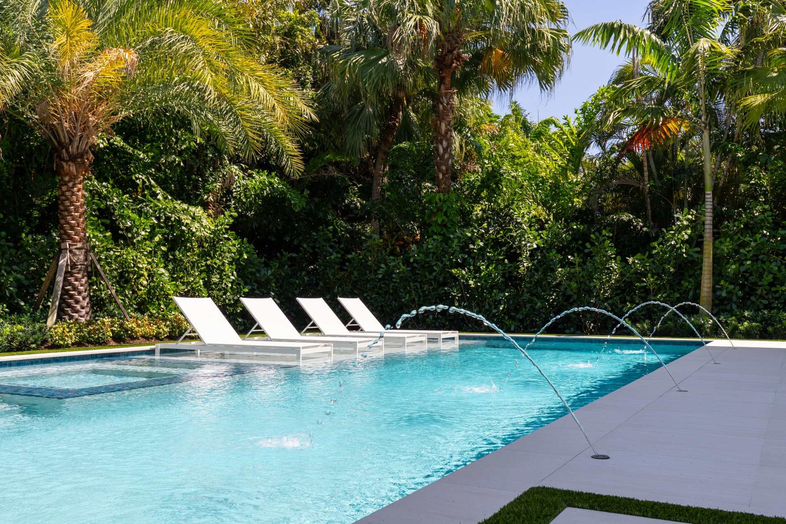 Piscine équipée de jets d’eau, entourée d’une végétation dense, pisciniste à Avon